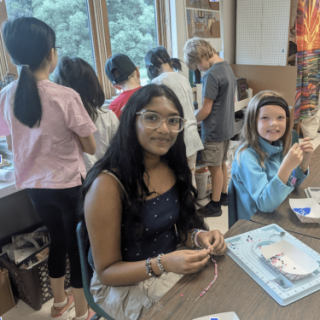 Varnika assisting campers in Jewelry Making